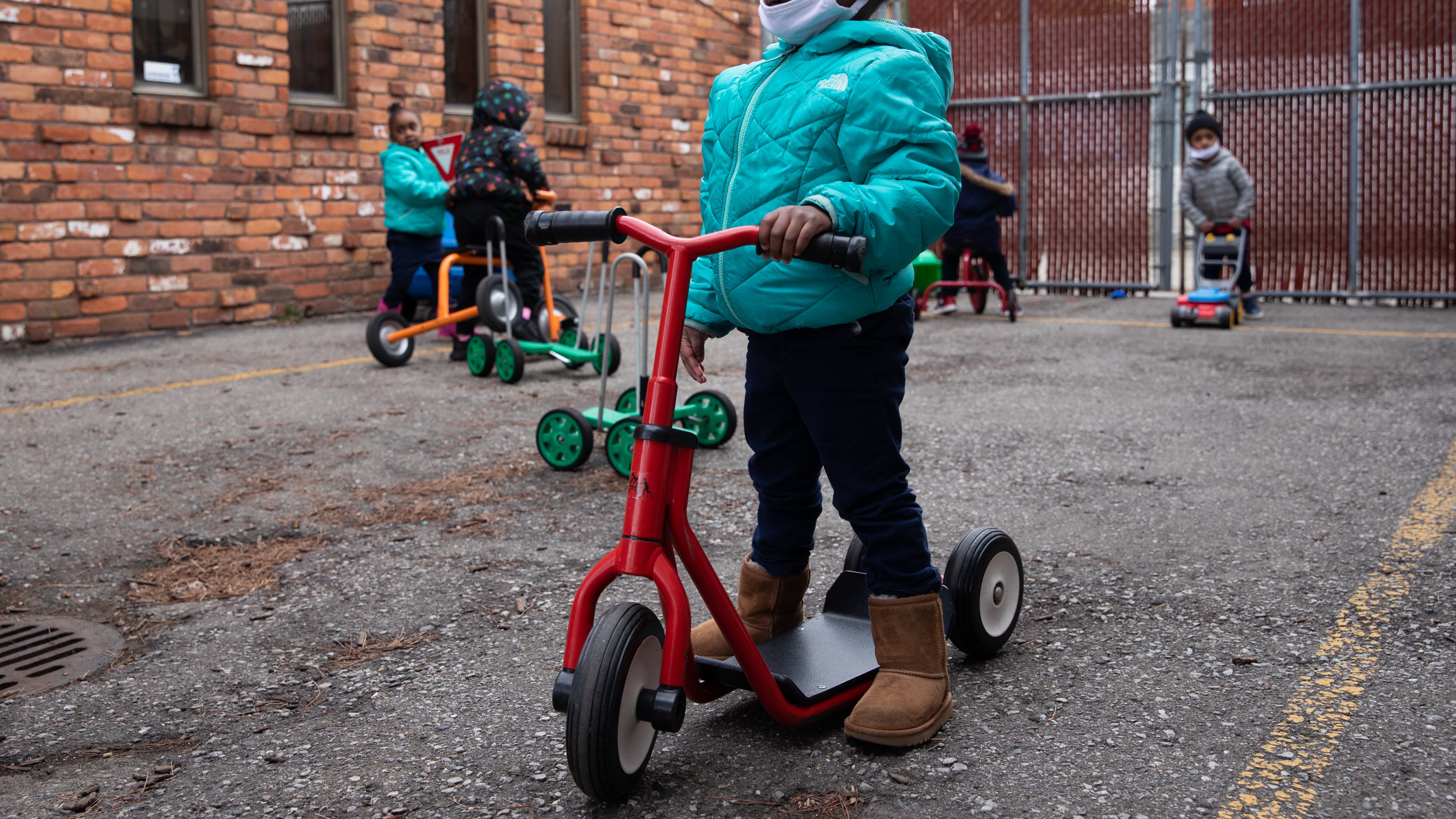 Payton Watson (front) rides around on a scooter as the preschoolers play outside at Little Scholars child care center in Detroit, Michigan, U.S., on Thursday April 1, 2021.