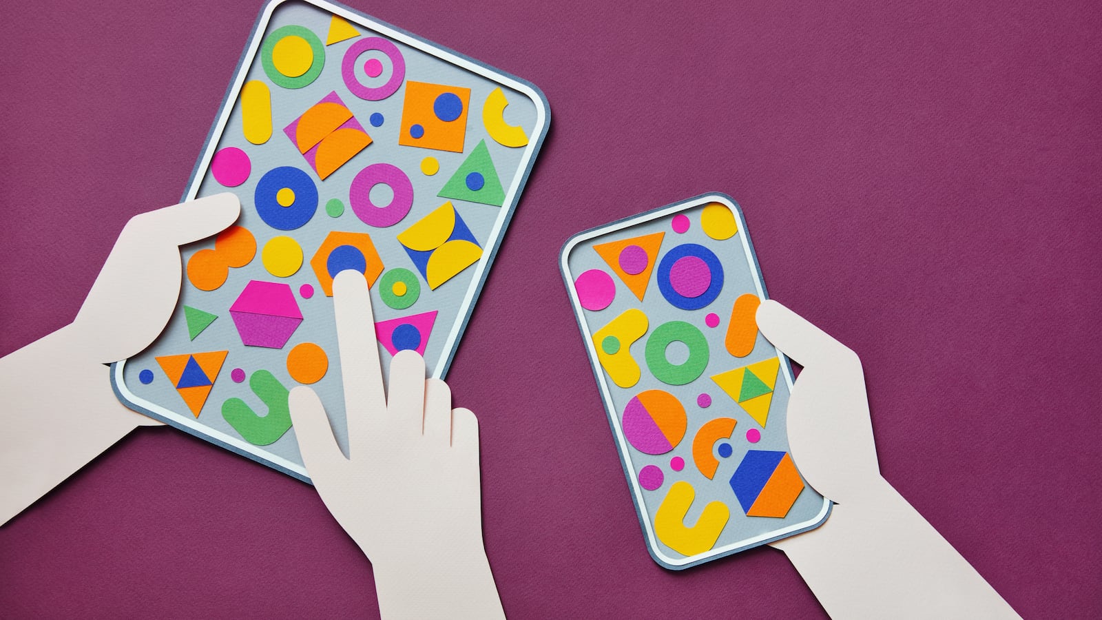 Paper craft illustration of hands holding digital tablet and smartphone with multi-colored geometric shapes. The backdrop is magenta.